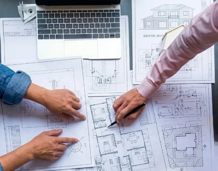 Réunion de maîtrise d'œuvre ADM autour des plans d'un projet de bâtiment dans le Loiret